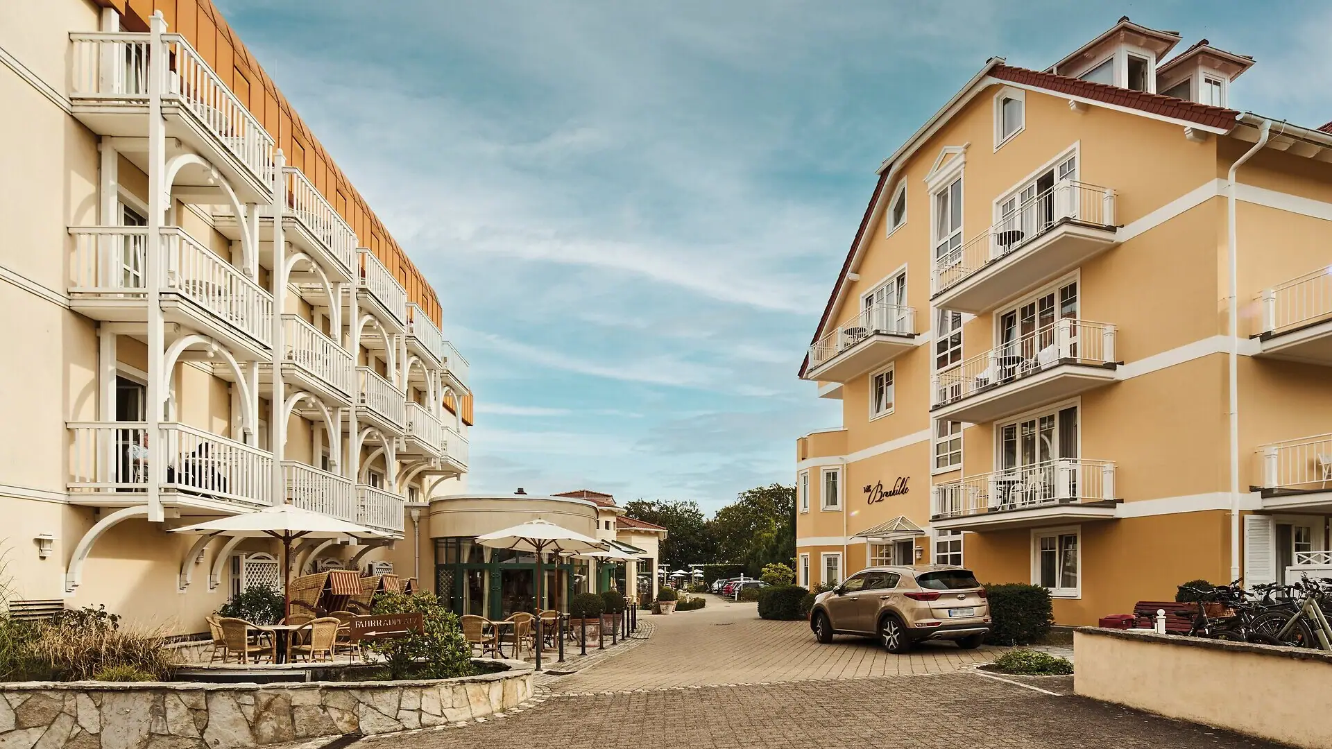 Hotelauffahrt Straße mit Gebäuden und geparkten Autos.