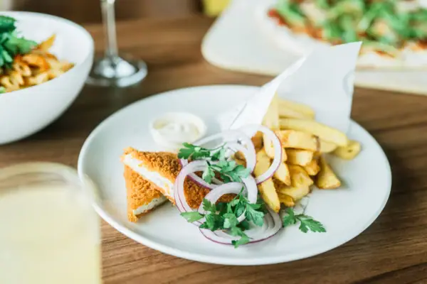 Fisch vom Feld Ein Teller mit Fast Food auf einem Tisch.