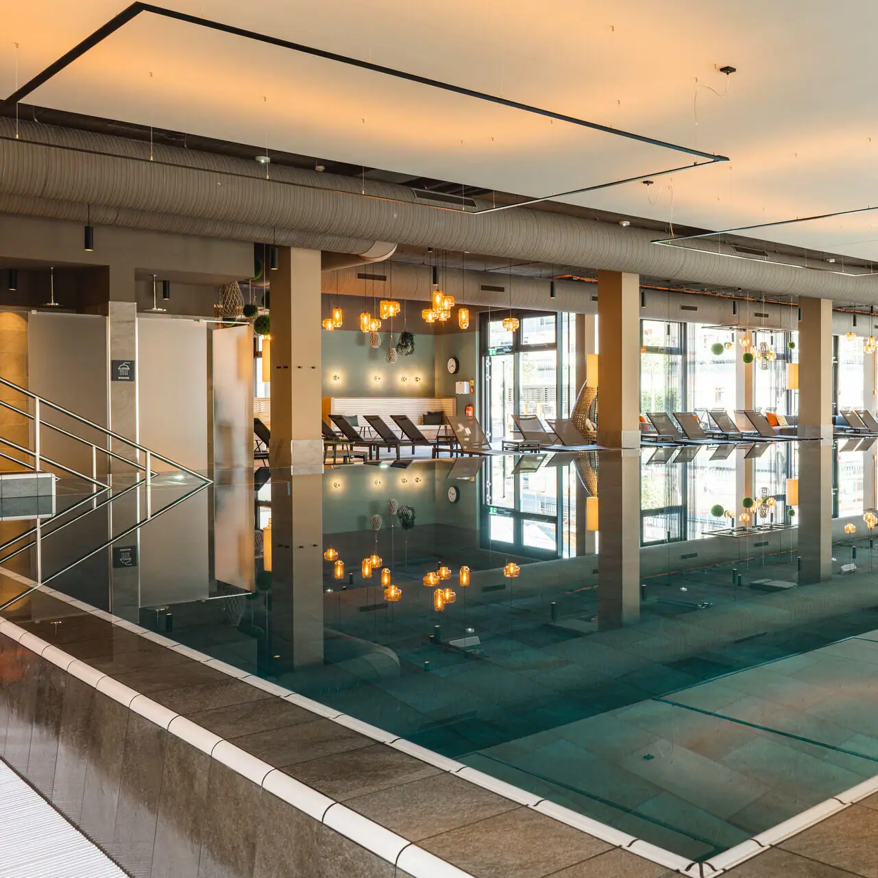 Innenpool Ein großes Hallenbad mit Stühlen und einer Person, die in der Mitte steht.