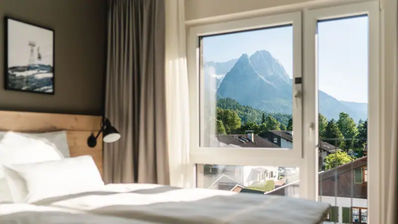 Zimmer mit Bergblick Ein Schlafzimmer mit einem Fenster und Blick auf Berge.