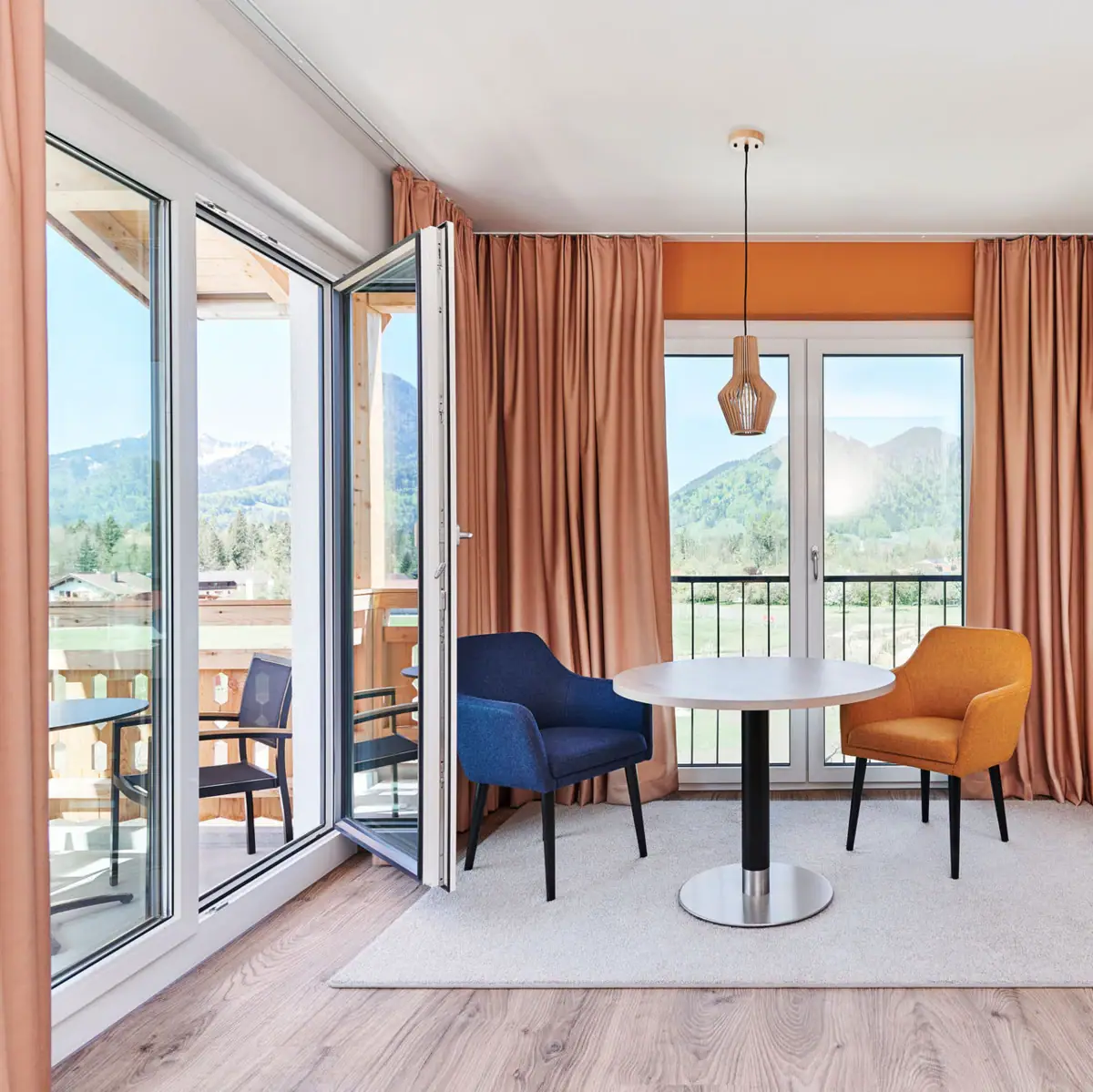 Suite mit Balkon aja Ruhpolding Ein Raum mit einem Tisch und Stühlen.