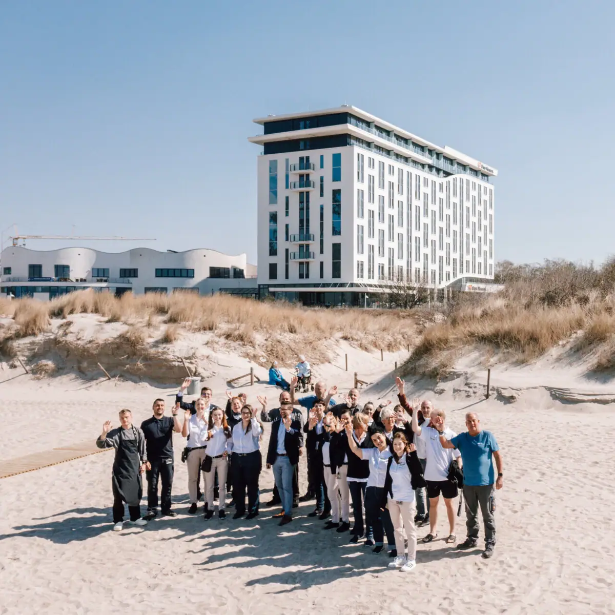 Eine Gruppe von Menschen posiert vor einem Gebäude.