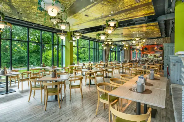 Restaurant im aja Bad Saarow Ein Raum mit Tischen und Stühlen.