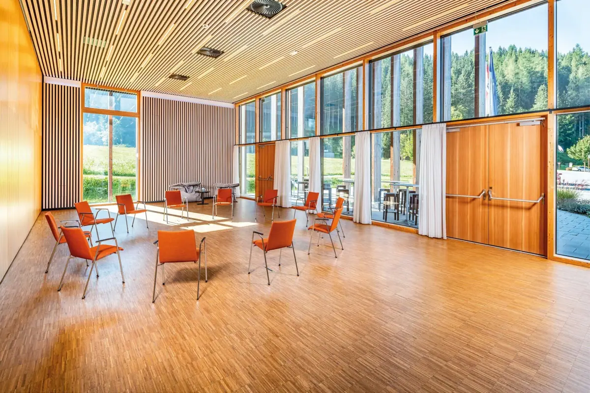 Tagungszentrum Werfenweng Tagungszentrum Werfenweng mit Tischen und Stühlen und großen Fenstern.