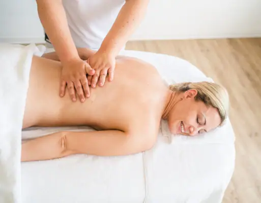 Massage Eine Frau liegt auf einem Massagetisch.