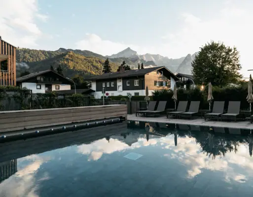 Außenpool Pool mit Stühlen und Gebäude im Hintergrund