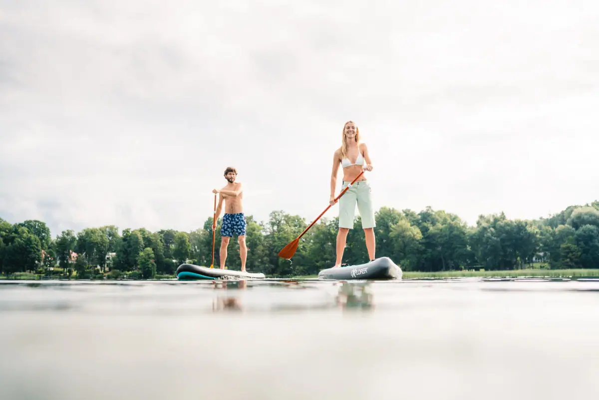 SUP Boards Zwei Personen auf einem Paddleboard auf dem Wasser.