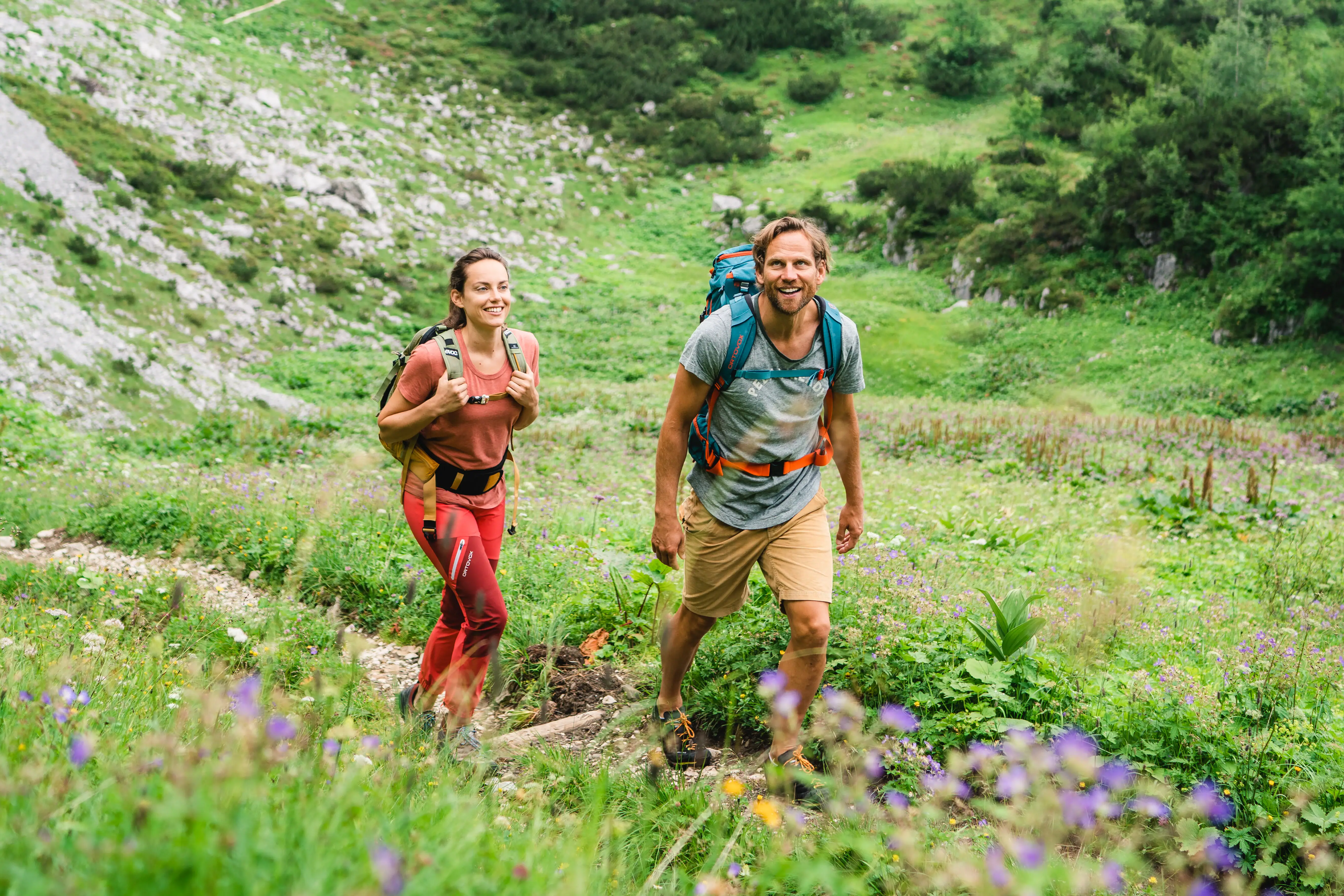 Wandern Garmisch-Partenkirchen Eine Frau und ein Mann wandern auf einem kleinen Pfad durch eine Bergwelt.