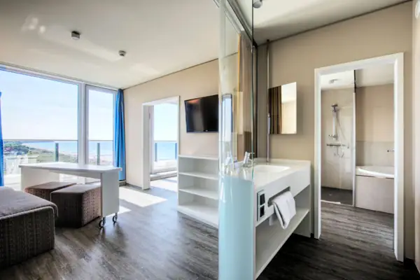 Suite im aja Warnemünde Suite mit Fernseher und und Badezimmer mit Dusche und Badewann