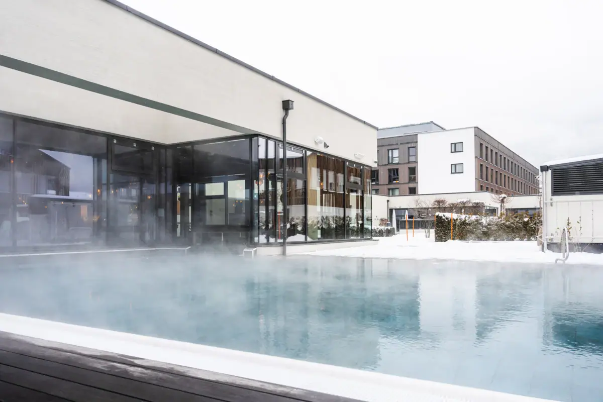 Außenpool Ein dampfender Pool im Freien unter klarem Himmel.