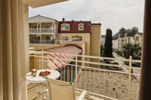 Balkon Balkon mit Tisch und Stühlen, auf dem ein Teller mit Essen steht.