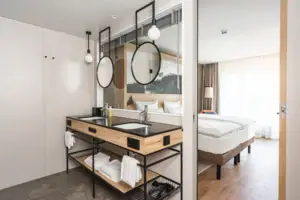 Suite Bergblick Ein Badezimmer mit Doppelwaschbecken und Spiegel.