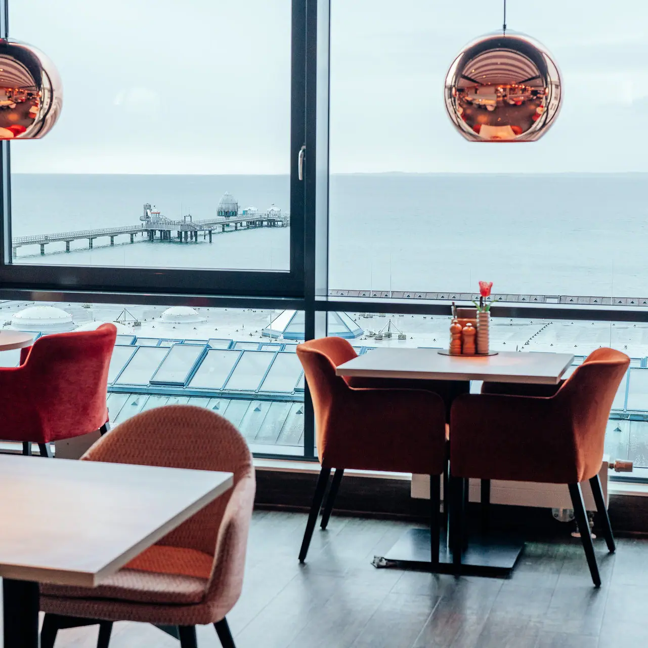 Restaurant Ein Raum mit Blick auf den Ozean und einen Pier.