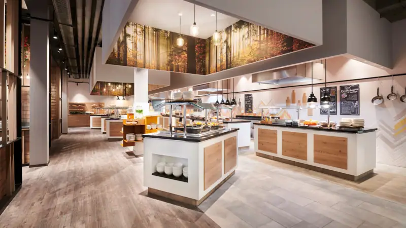 Buffetbereich im aja Ruhpolding Ein Restaurant mit Speisen auf der Theke.