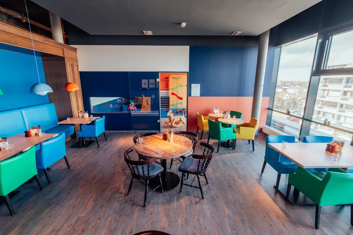 Kinderbereich Ein Raum mit Tischen und Stühlen.