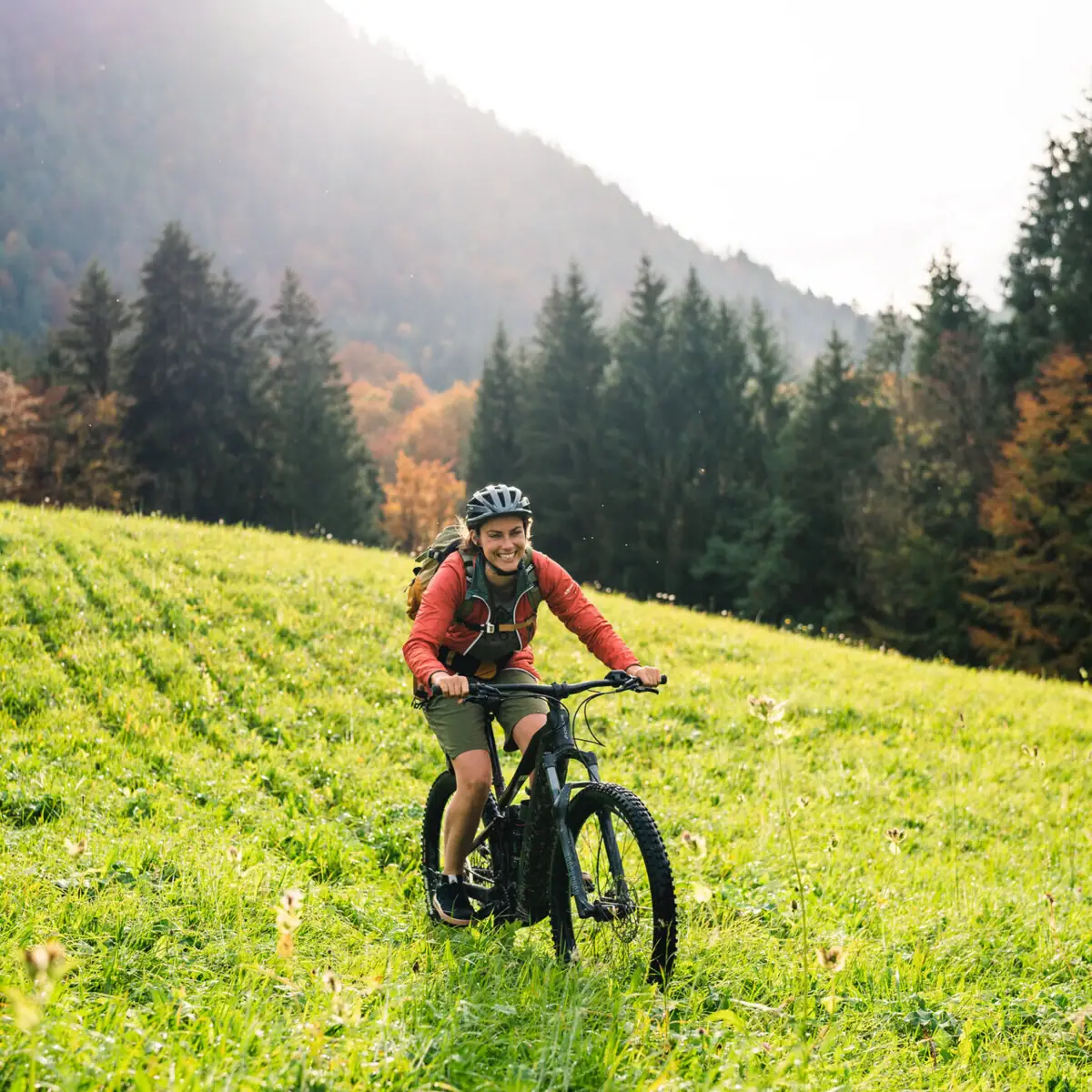 Fahrradfahren in Ruhpolding Ein Mann fährt mit einem Fahrrad über ein grasbewachsenes Feld.