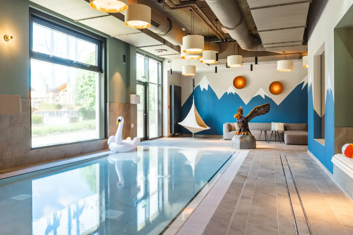 Kinderpool Ein Schwimmbecken mit einer Schwanen- und einer Vogelskulptur.