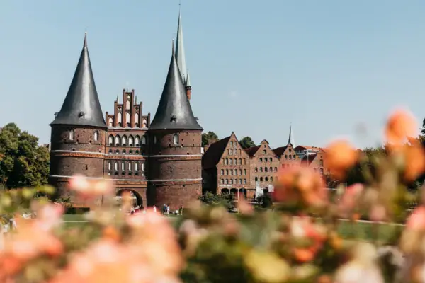 Lübeck Ein Gebäude mit Türmen und einem Rasen im Hintergrund.