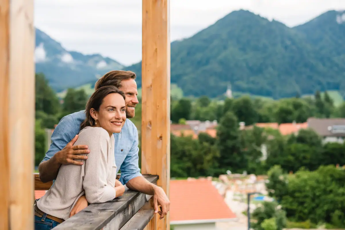 Ausblick vom Balkon aja Ruhpolding Ein Mann und eine Frau lehnen an einem Geländer.