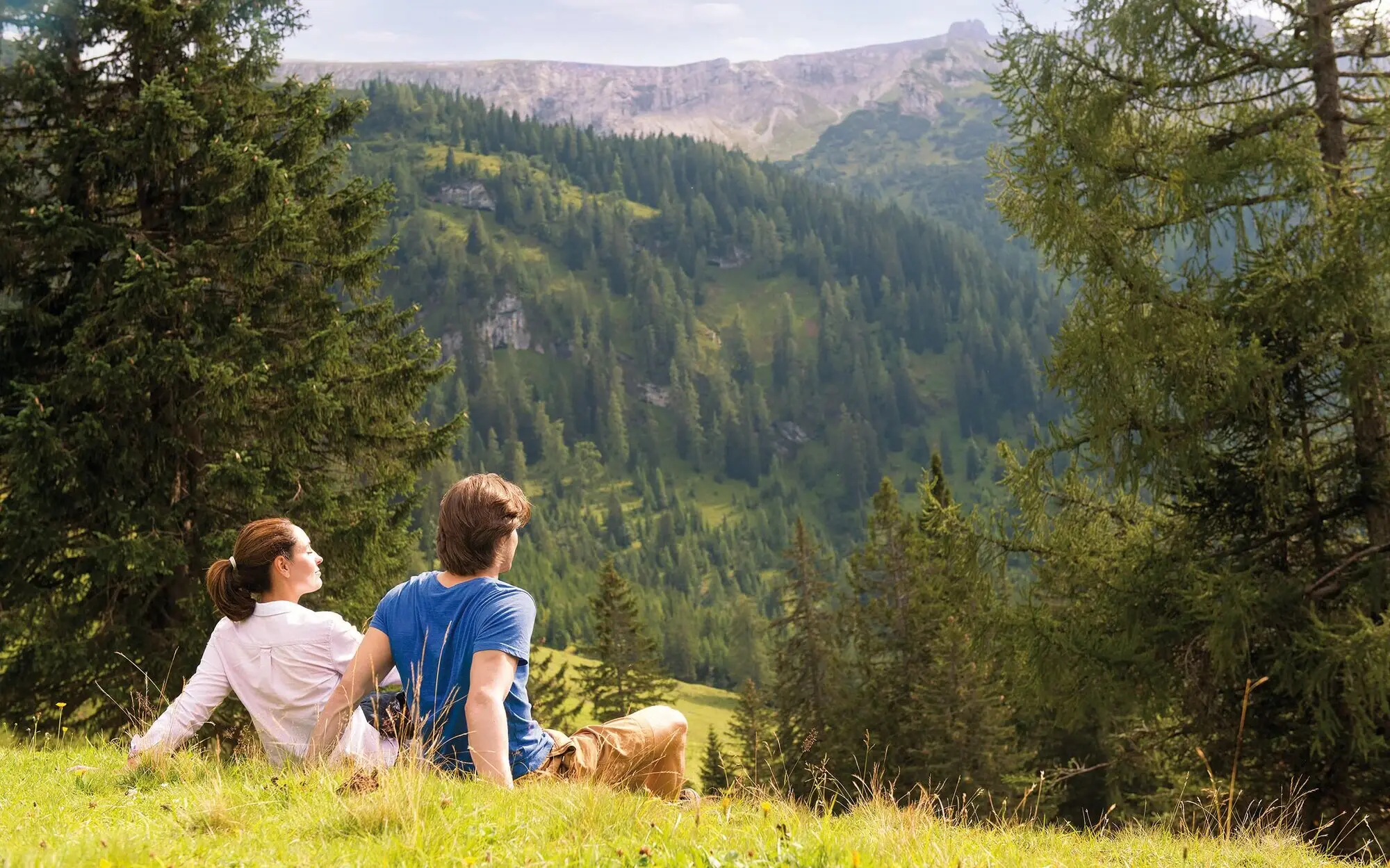 Hütte auf einem Hügel mit Berglandschaft im Hintergrund.