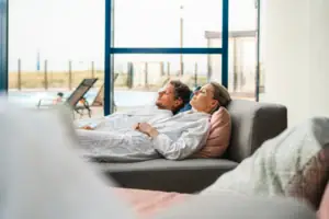 SPA Ein Mann und eine Frau liegen im Bademantel auf einer Couch.