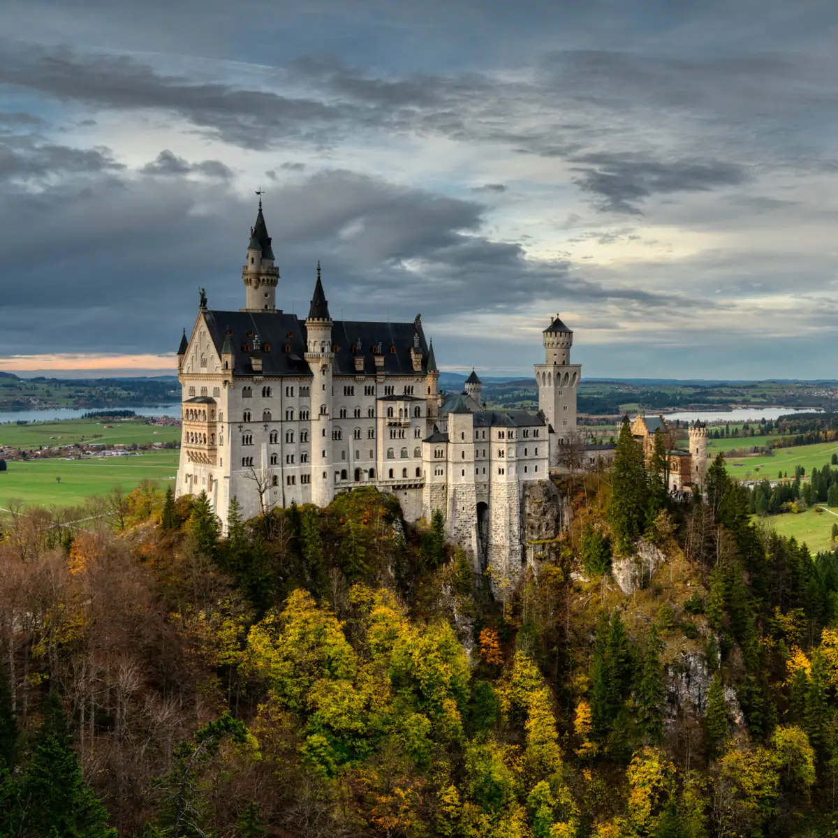 Schloss Neuschwanstein Das Schloss Neuschwanstein auf einem Hügel mit herbstlichen Bäumen im Vordergrund.