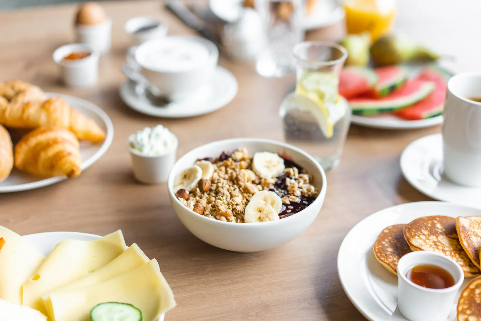 aja Frühstück Ein Frühstückstisch mit Getränken, Müsli und weiteren Speisen.