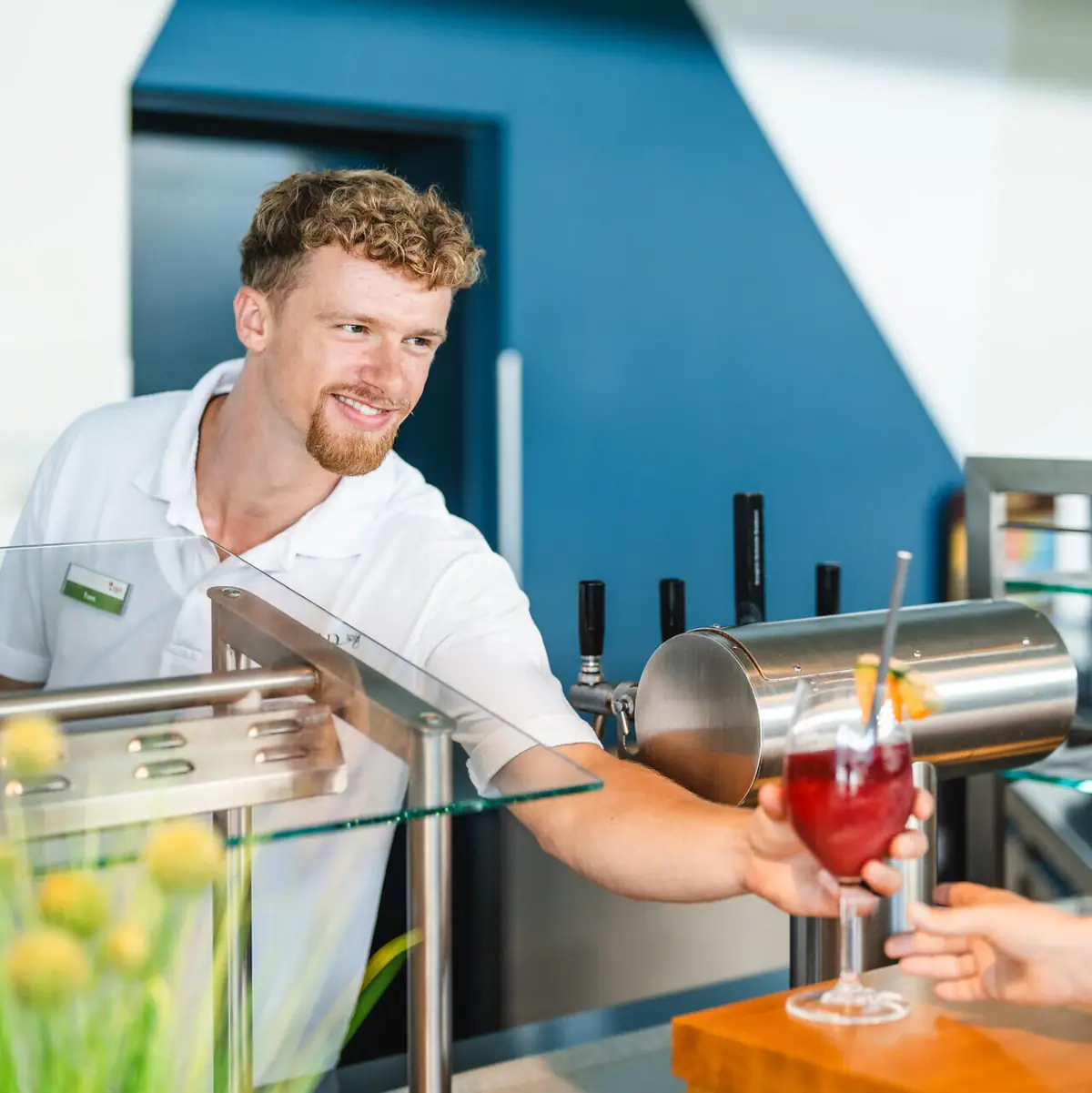 Poolbar Ein Mann reicht einem Kunden ein Getränk.