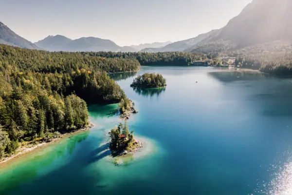 Eibsee Ein See umgeben von Bäumen und Bergen.