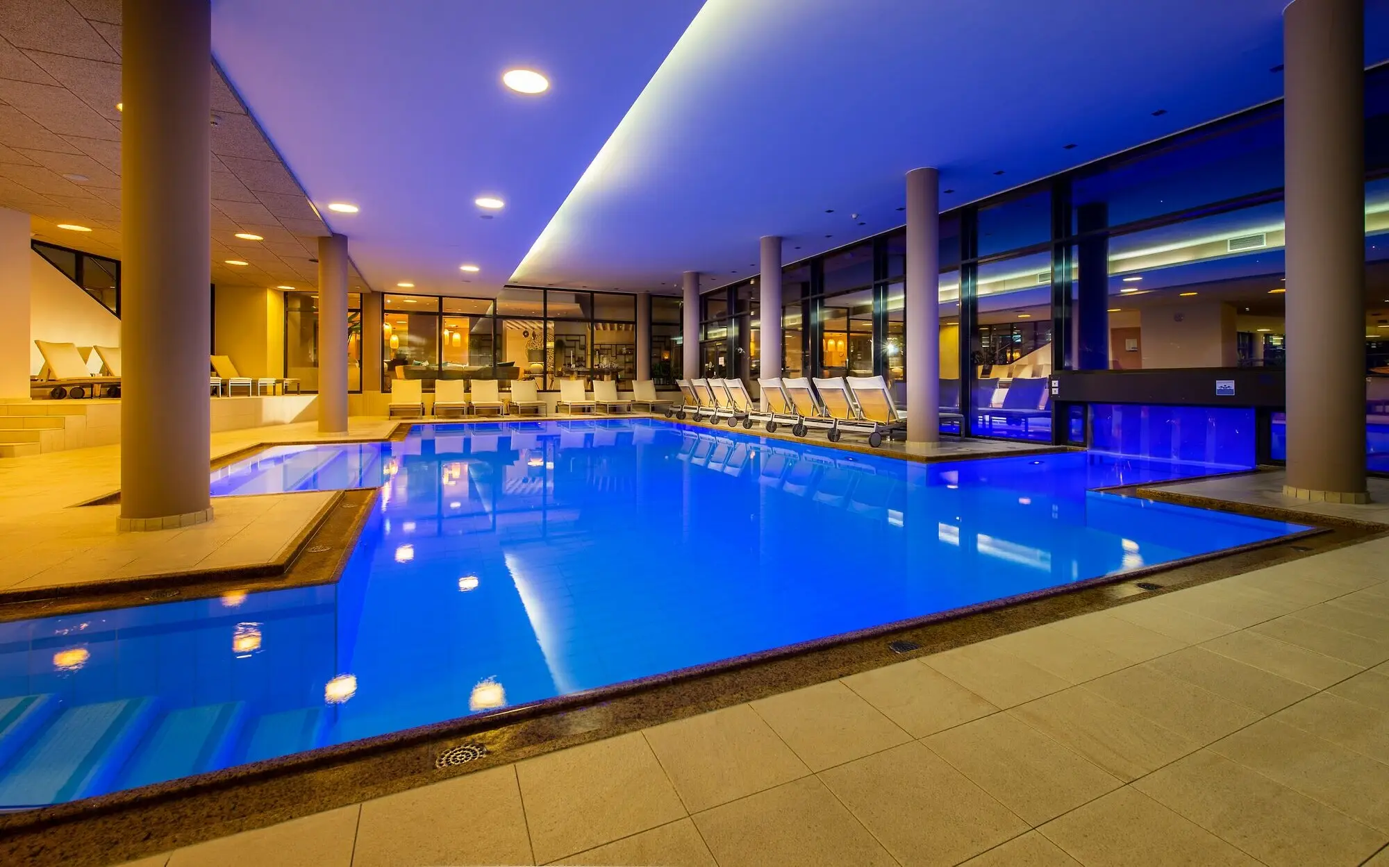 Innenpool aja Fürstenhaus Innenpool in einem Gebäude bei Nacht, mit blauem Wasser.
