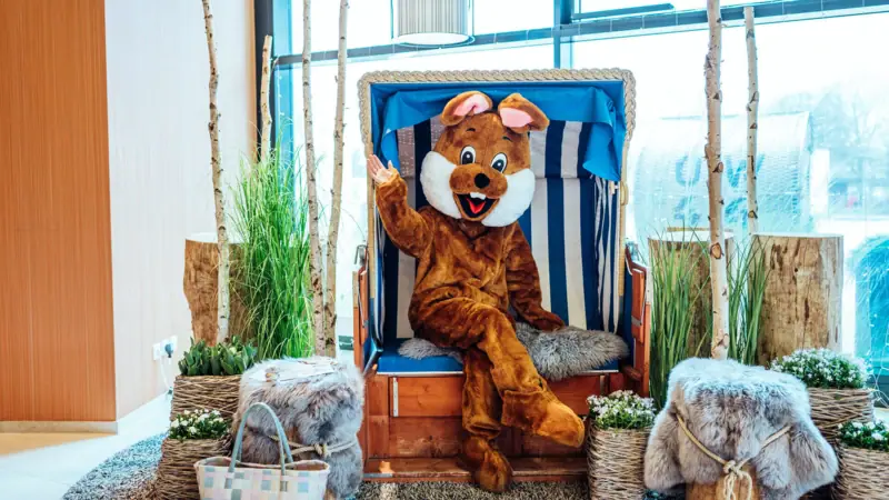 Osterhase Eine Person in einem Kleidungsstück sitzt auf einem Stuhl.