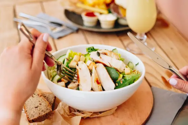 Bar Food Eine Person isst einen Salat in der aja Bar Garmisch-Partenkirchen.