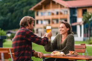 Biergarten Ein Mann und eine Frau sitzen an einem Tisch mit Essen und Getränken.