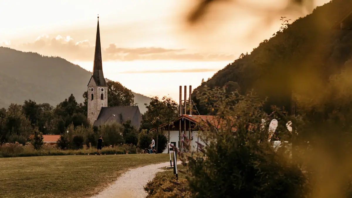 Ruhpolding Ein Weg, der zu einer Kirche führt.