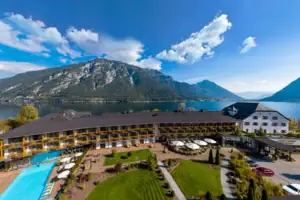 aja Fürstenhaus am Achensee Ein Gebäude mit Pool und Rasenflächen an einem See.