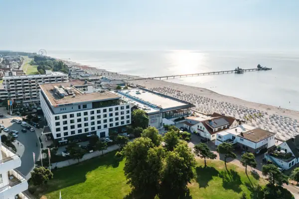 aja Grömitz Ein Gebäude neben einem Gewässer.