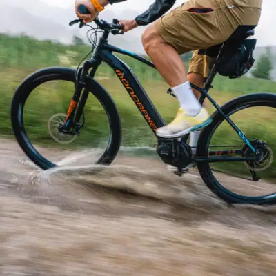 Mountainbike Eine Person fährt Fahrrad durch eine Pfütze.