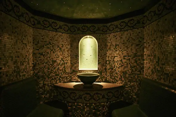 Dampfbad Ein Dampfbad mit Waschbecken und Bänken.