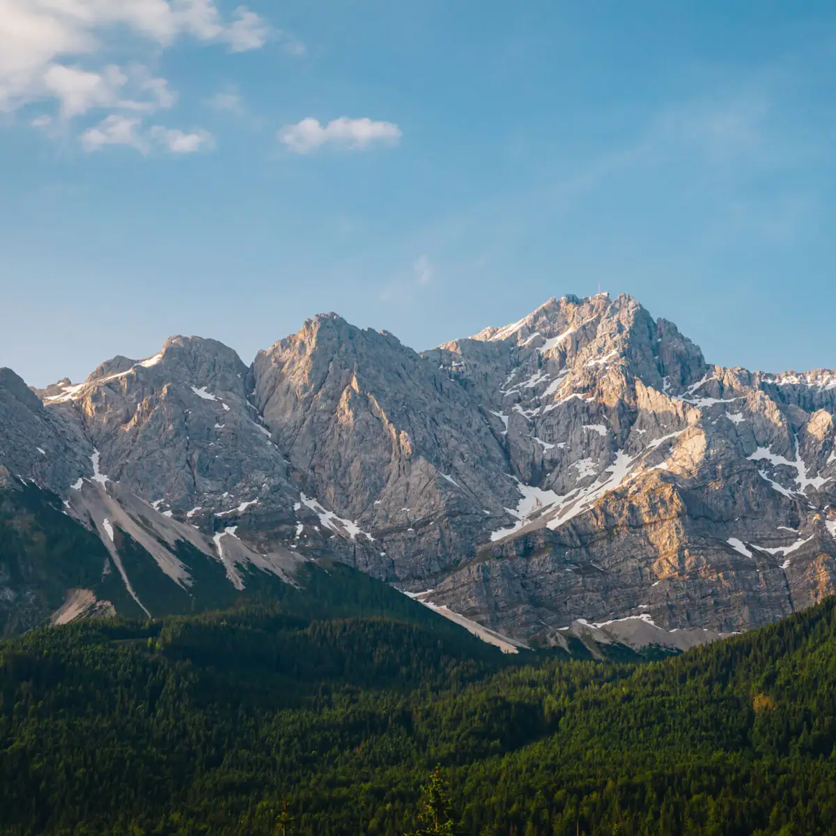 Zugspitze Bergkette mit Bäumen und blauem Himmel