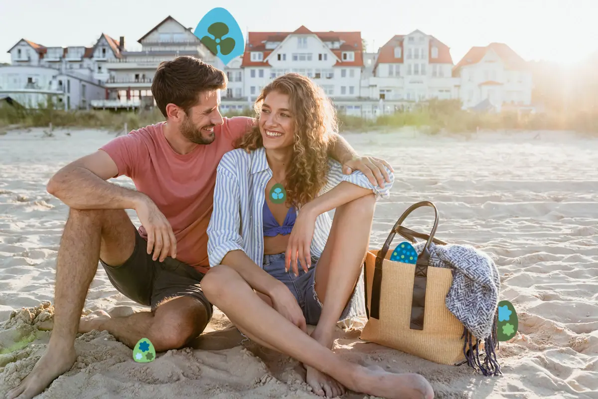Urlaub am Strand Ein Mann und eine Frau sitzen lächelnd am Strand.