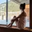 Sauna im aja Werfenweng Frau in einem Handtuch sitzt auf einer Fensterbank.