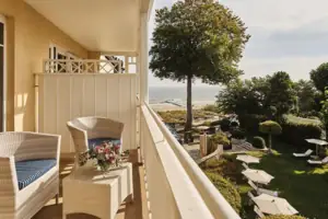 Balkon Ein Balkon mit Stühlen, einem Tisch und einem Baum.