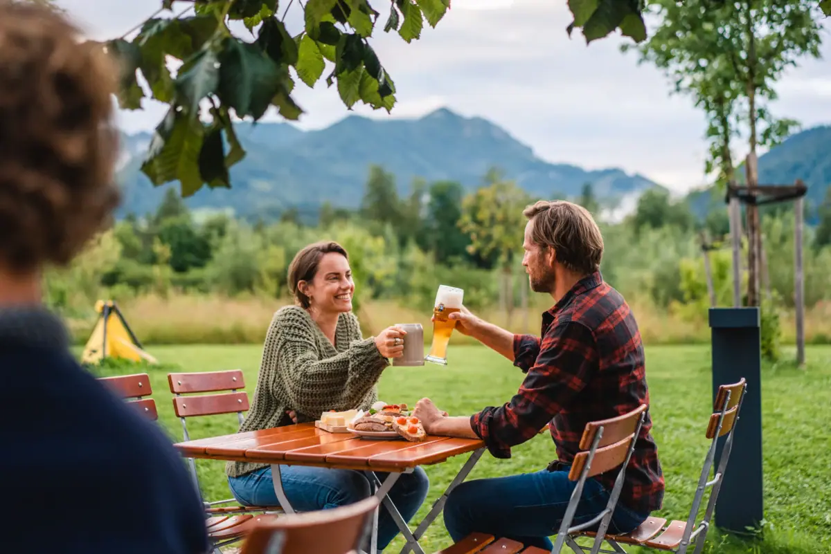 aja Bar Ruhpolding mit Biergarten Ein Mann und eine Frau sitzen im Biergarten vom aja Ruhpolding.