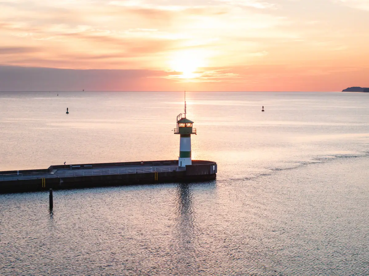 Travemünde Ein Pier mit einem Leuchtturm im Wasser.