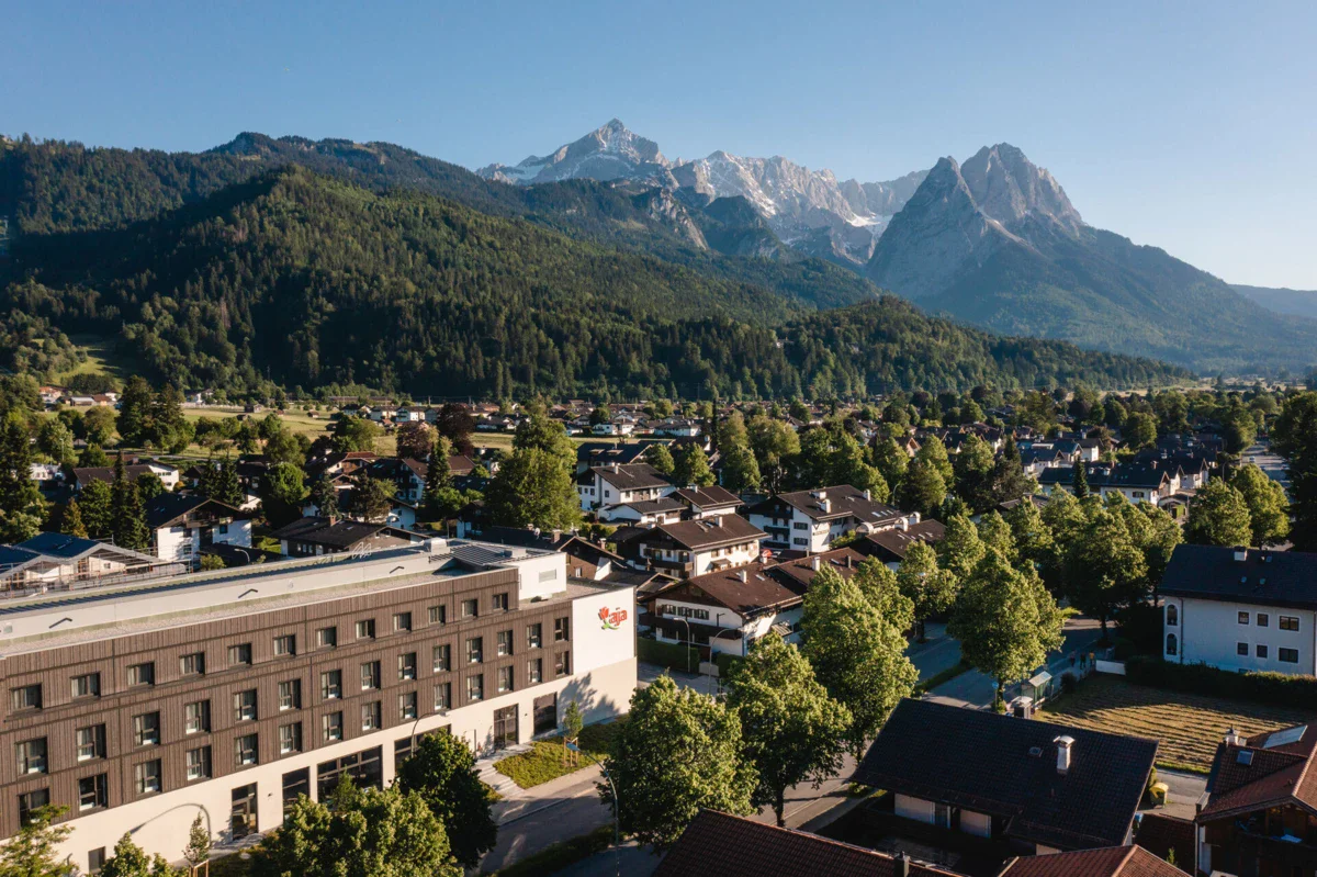 aja Garmisch-Partenkirchen Eine Stadt mit Bäumen und Bergen im Hintergrund.