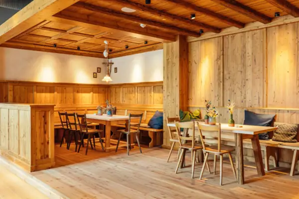 Bayerische Stube Ein Raum mit Holzwänden, Tischen und Stühlen.