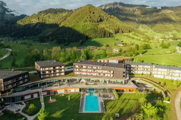 Bergresort Werfeweng Hotel mit Pool inmitten eines grünen Feldes