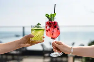 Bar Ein Paar Hände hält Cocktails mit Erdbeergarnitur.