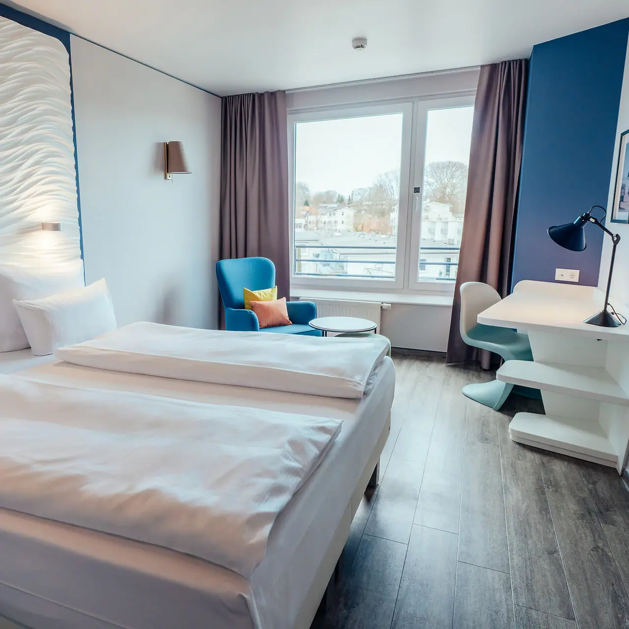 Doppelzimmer Ein Zimmer mit zwei Betten und einem Tisch.