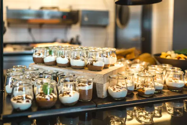 Dessert Eine Gruppe kleiner Gläser, gefüllt mit Desserts.